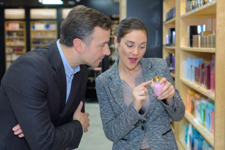 man with assistant help choosing beauty products at beauty shopの写真素材