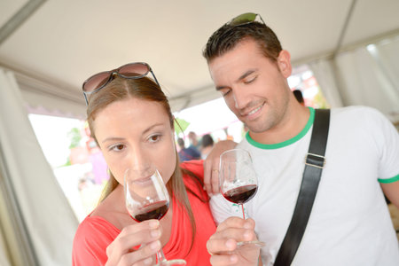 Couple assessing their glasses of red wine