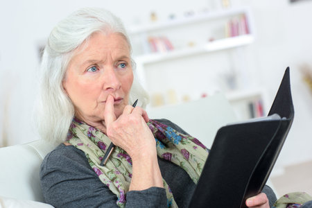 Pensive senior  with a notepad