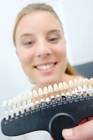 Lady showing teeth to match with color samplesの写真素材