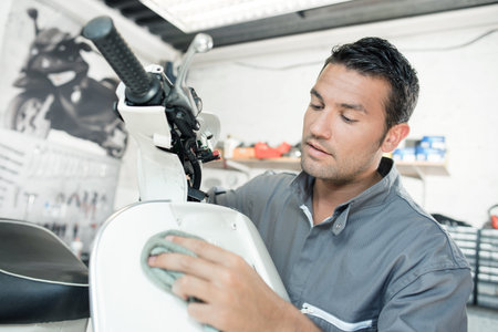 Mechanic cleaning a scooter