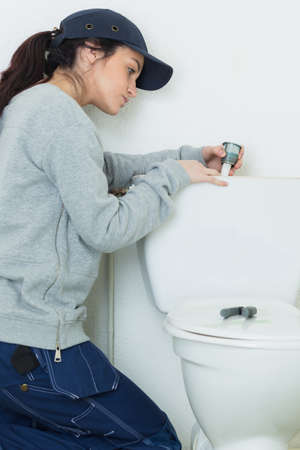 Woman fitting toilet cisternの写真素材