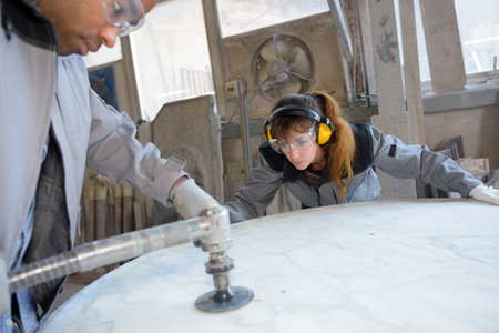 Man and woman sanding large circular surface