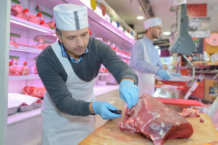 butcher slicing a meatの写真素材
