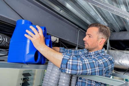 Electrician fitting a ventilation systemの写真素材