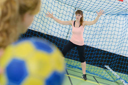 Woman defending goal in handball gameの写真素材