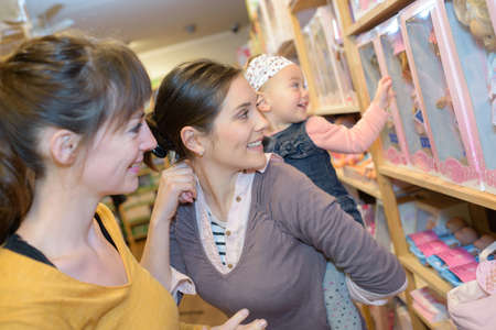 mother and daughter with attractive vendor in toy storeの写真素材