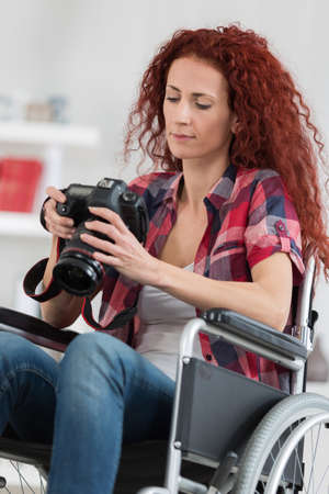 disabled woman taking pictures with dslr cameraの写真素材