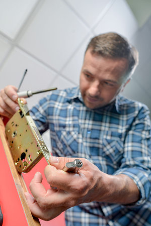 man installing door lock