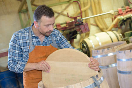 wood barrels production cooper using hammer and tools in workshopの写真素材