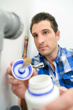 Plumber with a pot of glueの写真素材