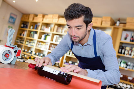 Man wrapping up bottle of wineの写真素材