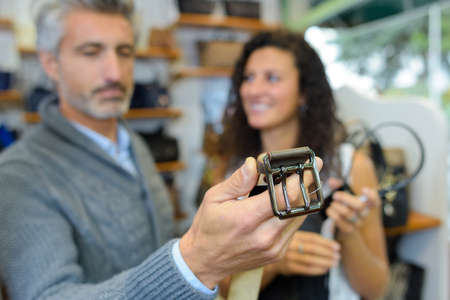 Customer appraising leather beltの写真素材