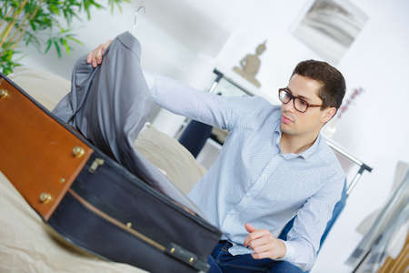 close up of businessman packing clothes into travel bagの写真素材