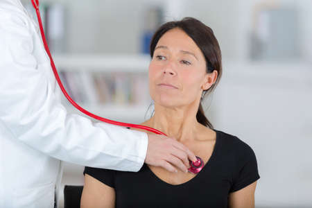 female doctor examining the patient with stethoscopeの写真素材