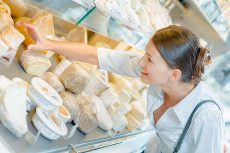 Woman shopping for some cheeseの写真素材