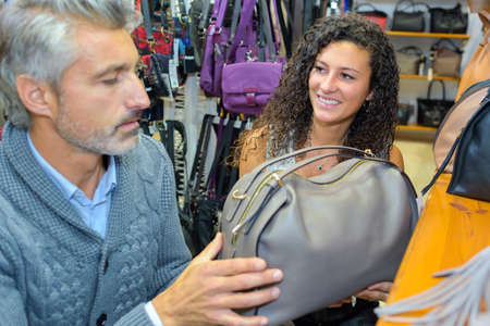 Man and lady in handbag shopの写真素材