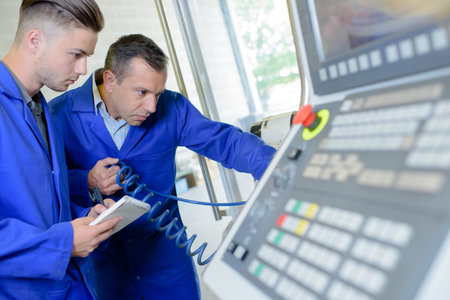 Two men with coiled pipe staring intently