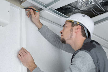 Man marking position of cable trunkingの写真素材