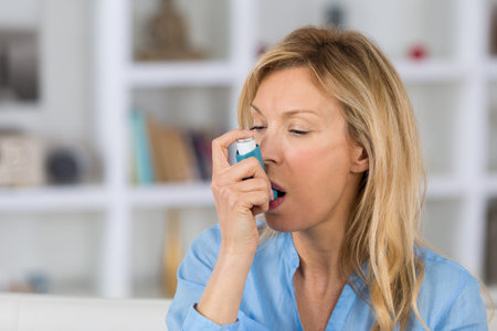 close-up of woman using the asthma inhaler in her living-room