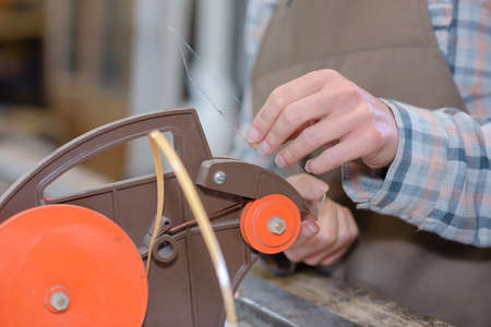 Woman operating glass cutting machineの写真素材