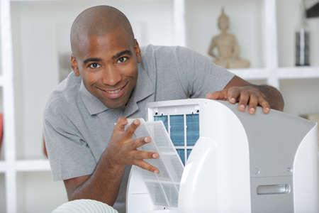 Man with mobile air conditioning unitの写真素材