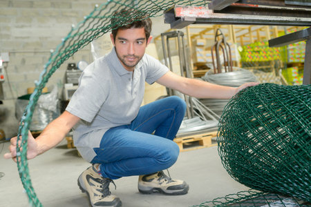 Man opening roll of fencing wire