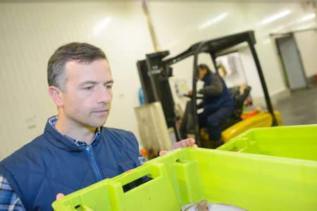 worker receiving fresh deliveryの写真素材