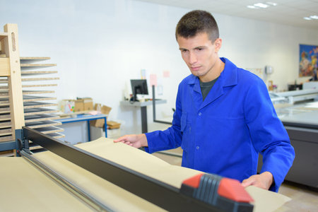 worker tending a paper machine