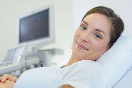 Portrait of lady on bed next to scannerの写真素材