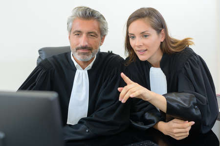 lawyers looking at computer in court gownsの写真素材