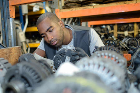 Man looking through parts in scrap yardの写真素材