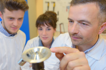 People looking at brass object