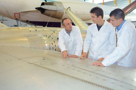 Team of men looking at aviation designsの写真素材