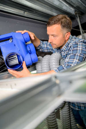 Man installing a new air conditioning unitの写真素材