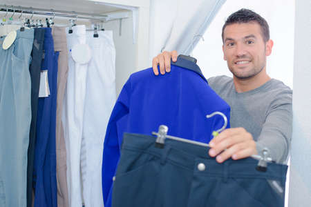 man showing clothes while shoppingの写真素材