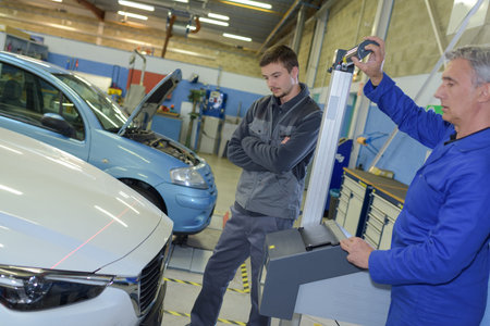 pairof mechanics checking a car