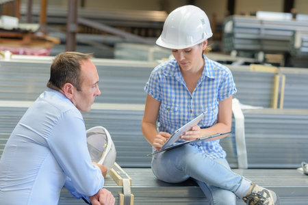 Woman showing screen of tablet to colleague
