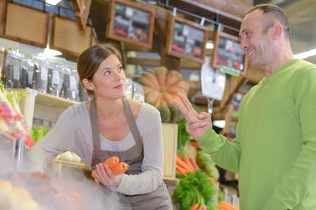 Man gesturing for two to shop assistantの写真素材
