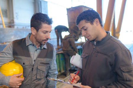 workers in warehouse with yellow safety helmetの写真素材