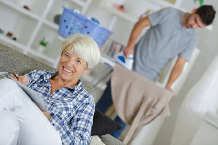 closeup of mature woman with home help ironingの写真素材