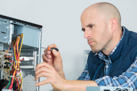 computer specialist use screwdriver to repair hardware