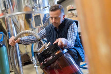 worker filling tank in factoryの写真素材