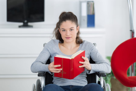 girl in wheelchair reading bookの写真素材