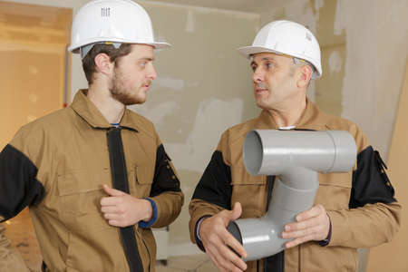 builders holding sewer pipesの写真素材
