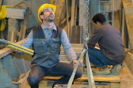 worker using an industrial hoist with the chain in factoryの写真素材
