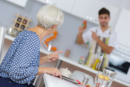 Man checking condiment for woman's mealの写真素材
