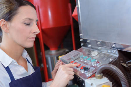 female worker operating a machine in a factoryの写真素材