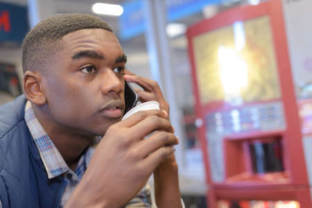 man talking on phone in coffee shopの写真素材