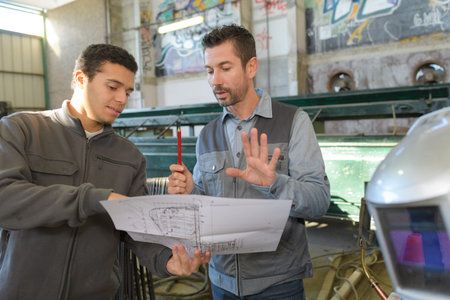 working engineers with factory plans